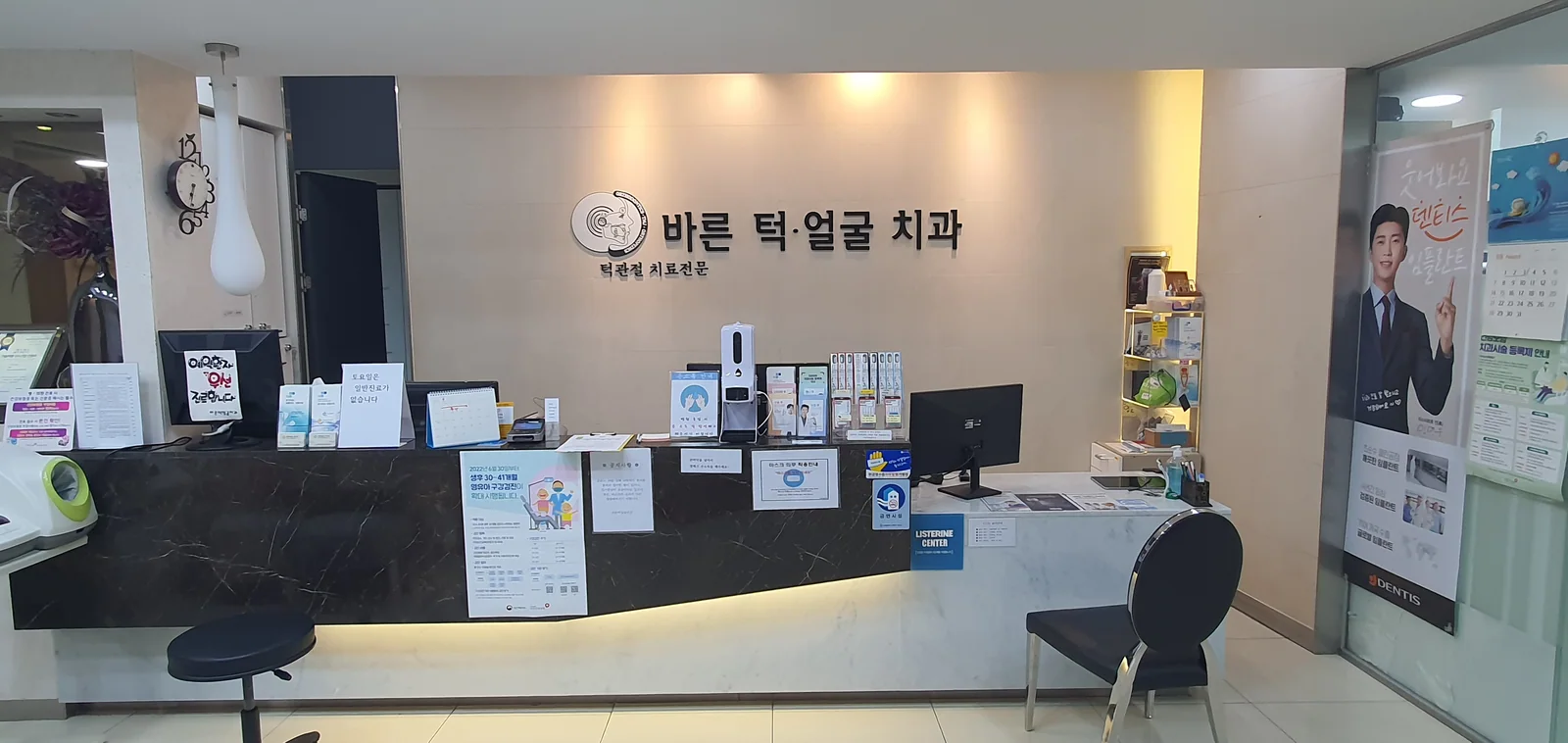 바른턱얼굴치과의원 안내데스크 로고월 — ‘바른 턱·얼굴 치과’ 사인과 접수 카운터